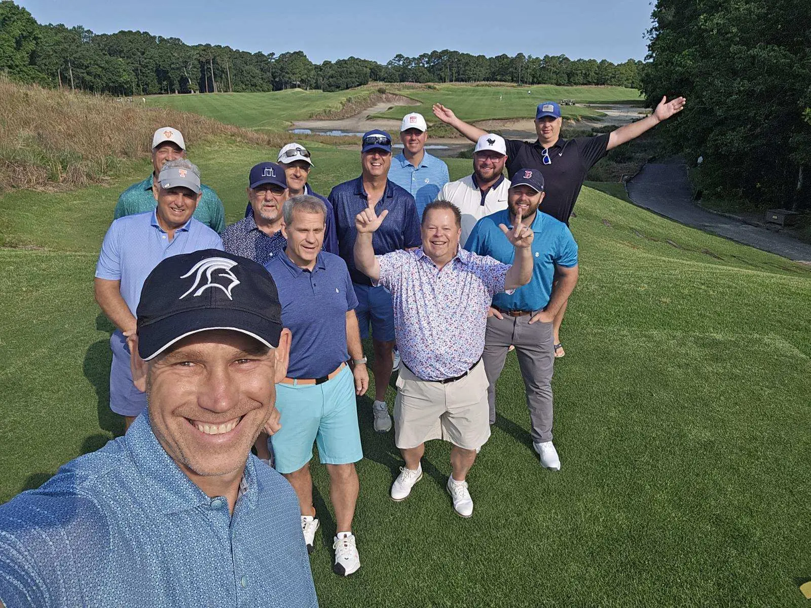 Large group of golfers gathered on a fairway for a photo