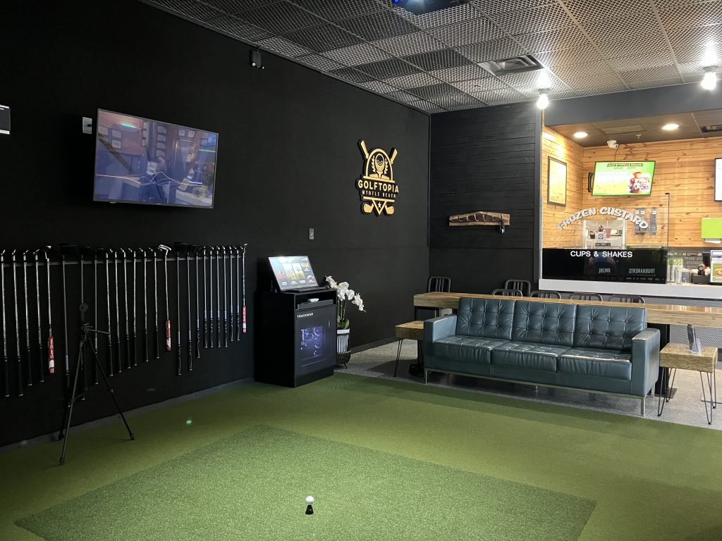 The Golftopia simulator room and club rack inside BurgerFi at Sayebrook Town Center