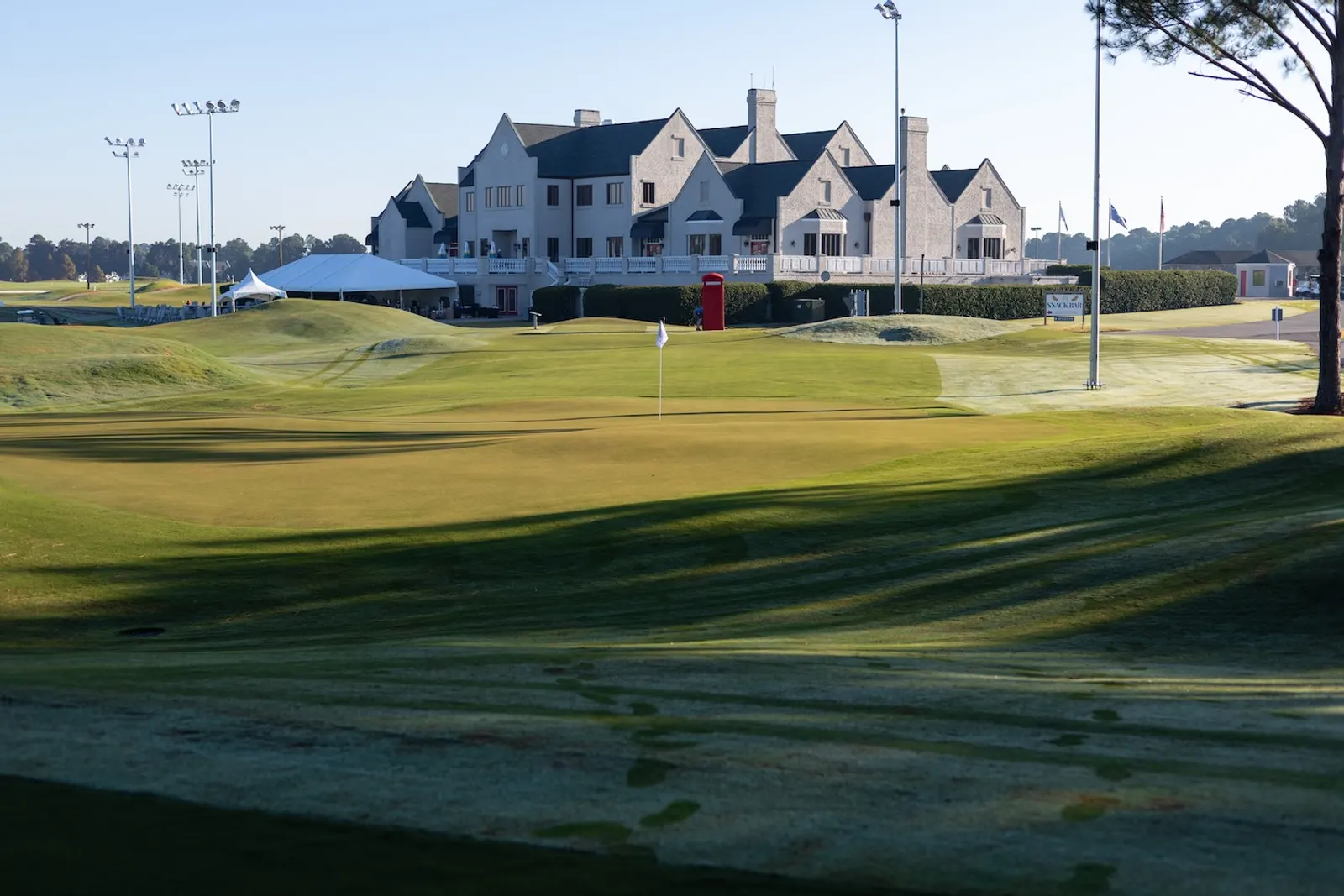 Looking back across a Piper green toward the Legends clubhouse, with the red telephone box visible on the right