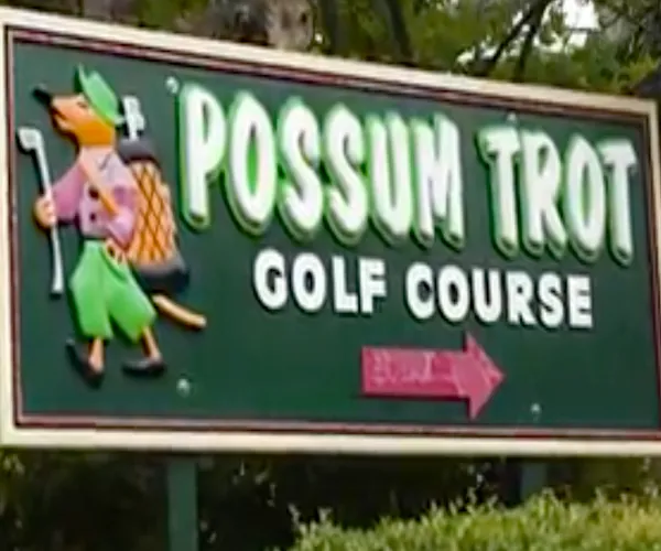 The green Possum Trot Golf Course entrance sign with a possum carrying a golf bag