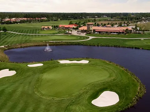Founders Inclusive package with a green and bunkers in front of a lake and clubhouse
