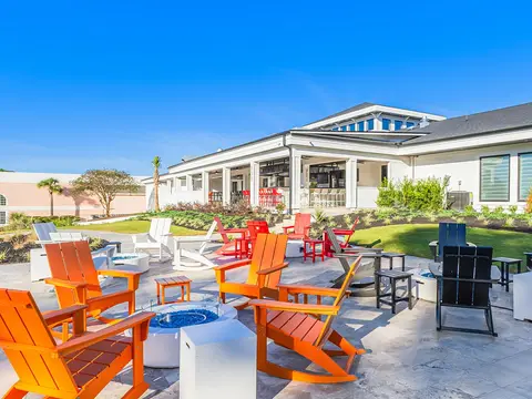 Sea Trail Stay and Play package with orange Adirondack chairs around a fire pit on the clubhouse patio